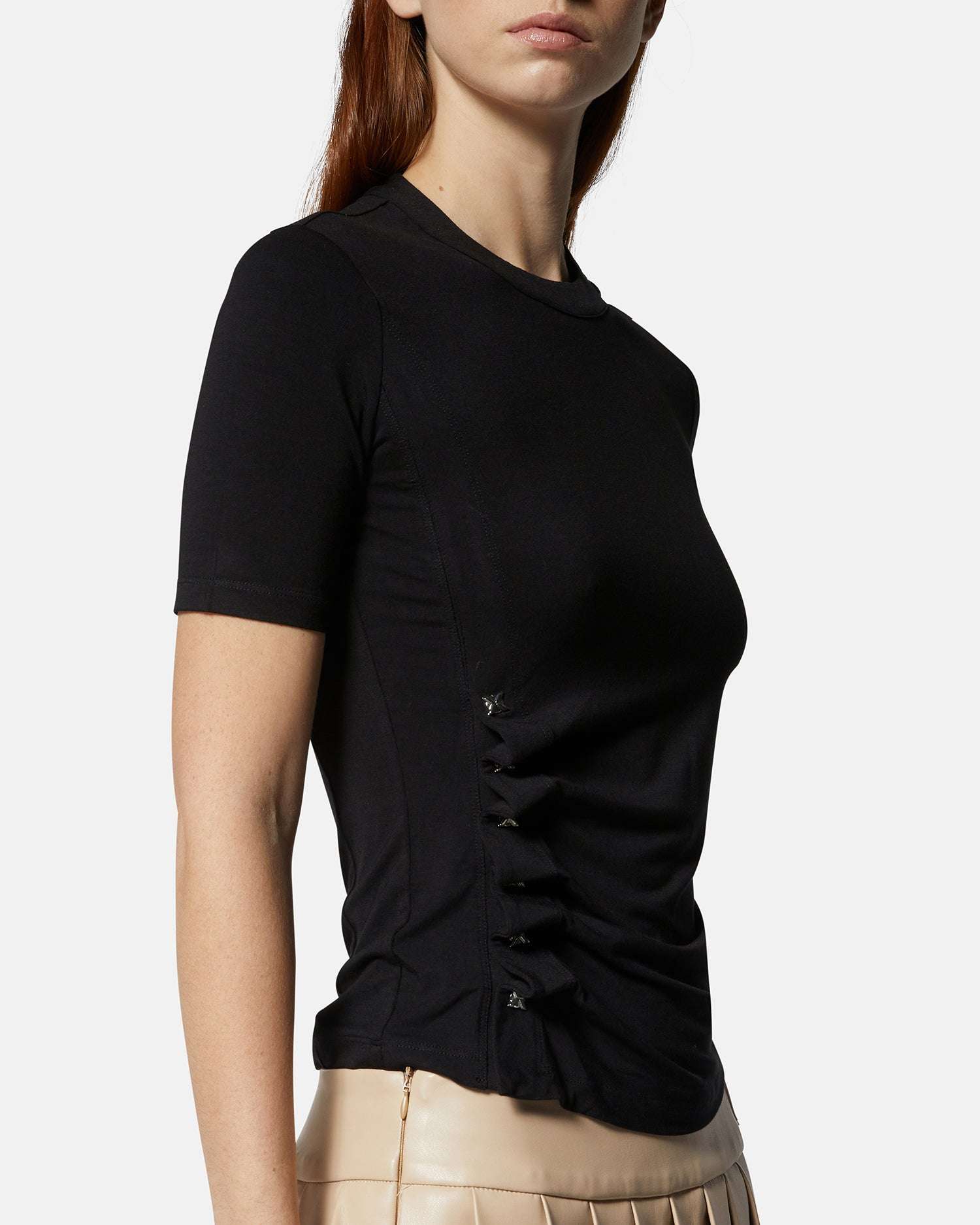 Top nero aderente con dettagli laterali e gonna plissettata beige Top