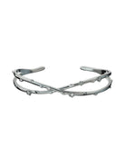 Bracciale rigido aperto con design a rami intrecciati e dettagli luminosi con motivi floreali.