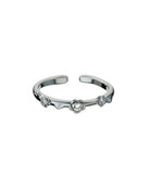 Anello aperto con tre piccoli fiori decorati da elementi brillanti, visto frontalmente su sfondo bianco.