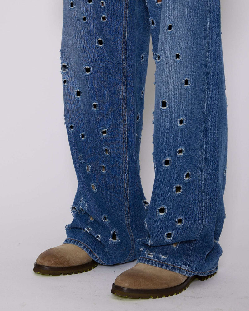 Jeans gamba larga con fori metallici sul davanti
