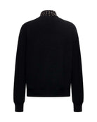 Maglione uomo nero con collo alto e dettagli metallici Maglia