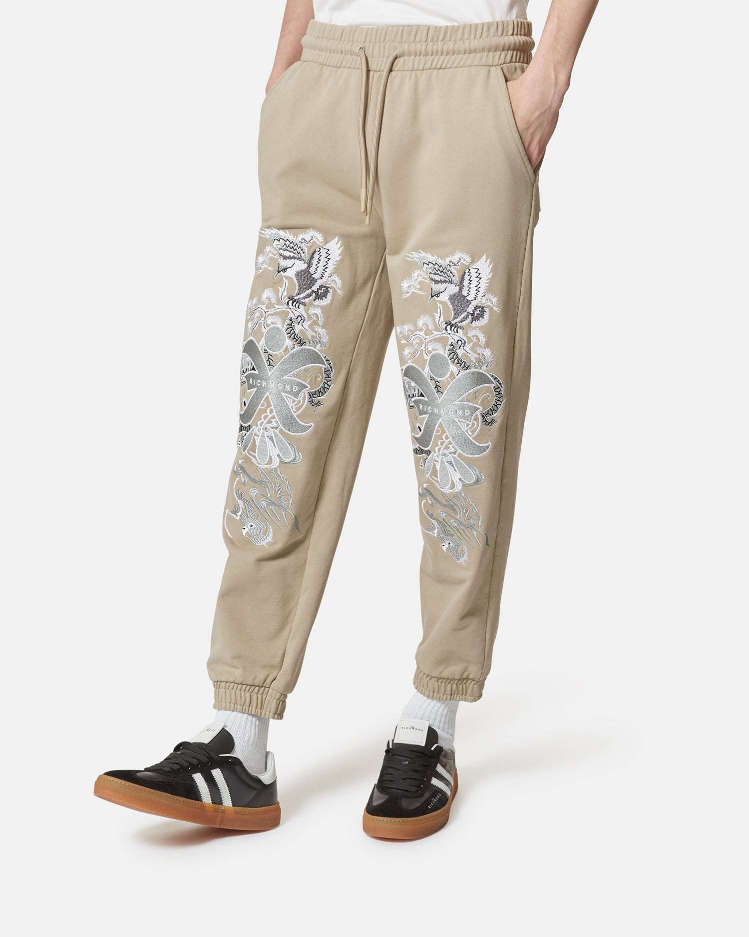 Pantaloni jogger beige con ricami decorativi Pantaloni