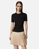 Top nero aderente con dettagli laterali e gonna plissettata beige Top